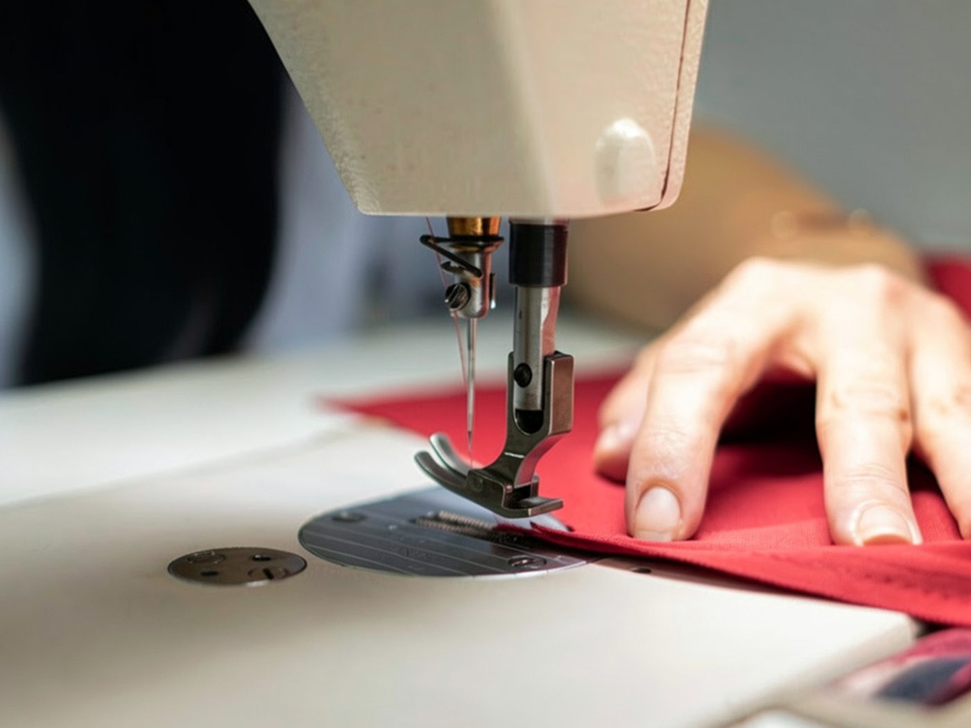 A seam being stitched in scarlet fabric under the needle